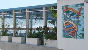 Un edificio con grandes ventanales y un mural de barcos en la pared.