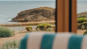 Un paisaje costero con un prominente afloramiento rocoso y vista al mar.