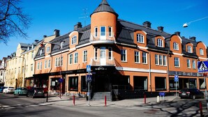 A corner building with a turret, multiple windows, and a sign for a restaurant.