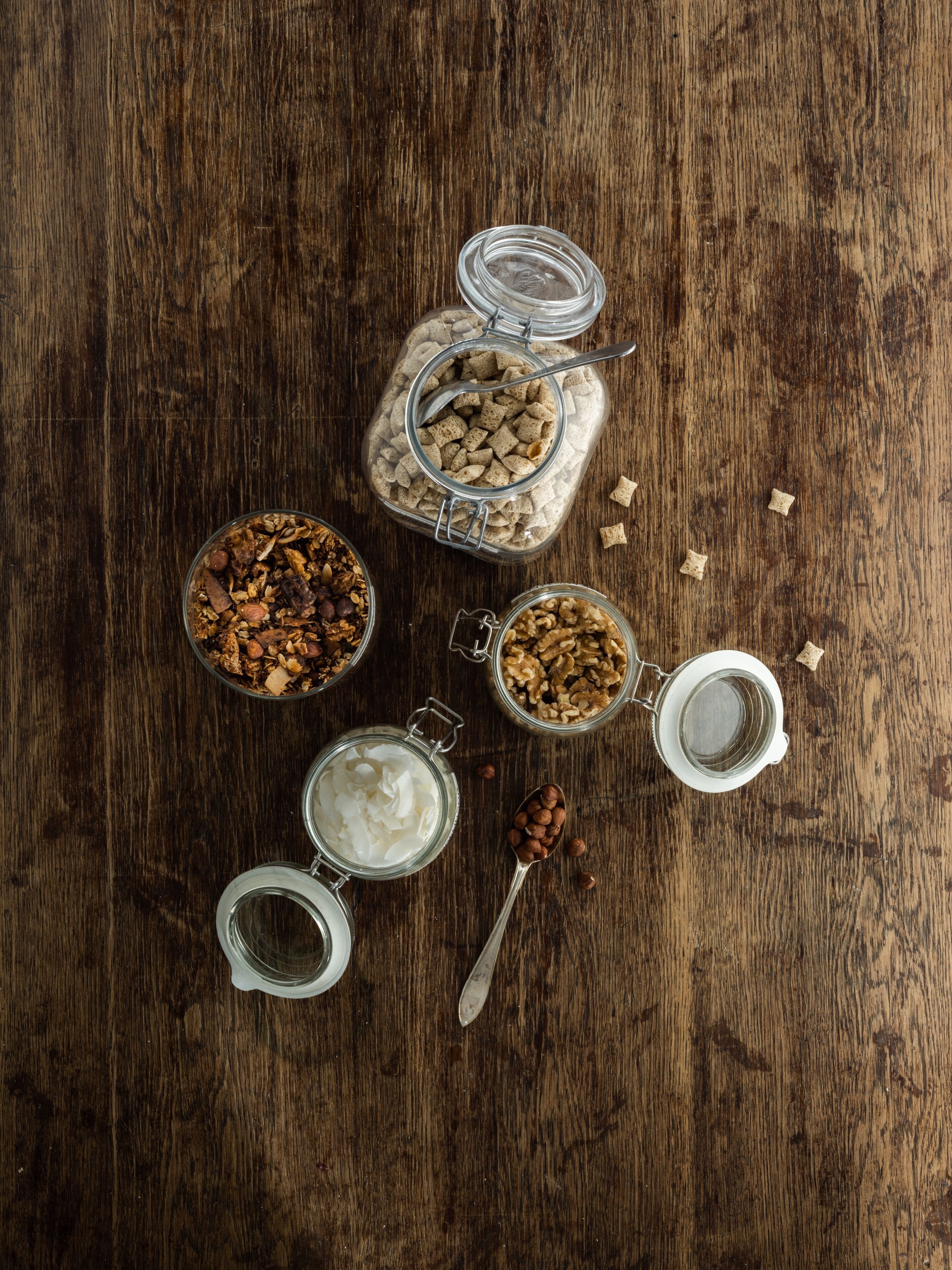 A wooden surface with several glass jars containing various food items.