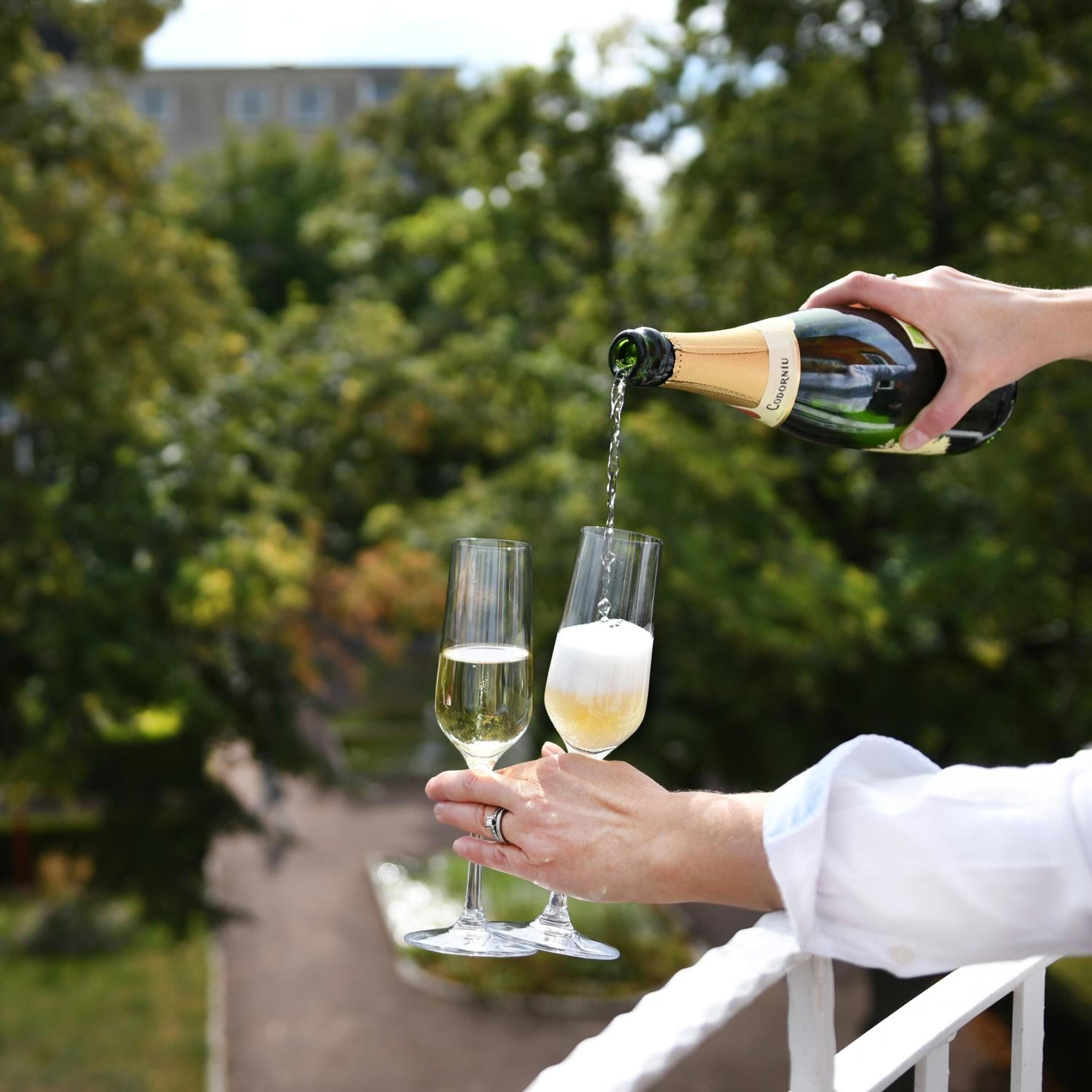 Une personne verse du champagne dans deux verres.