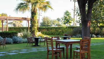 Una zona patio con posti a sedere all'aperto e un pergolato.