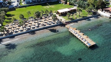 Praia particular, espreguiçadeiras, guarda-sóis