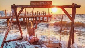A wooden swing set with a sign reading "beach of AKBULUT" in a coastal setting. - Hotel Akbulut (Kusadasi)