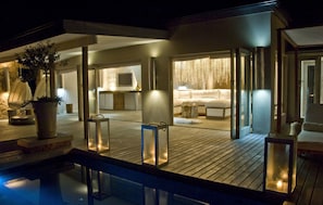 A modern, well-lit outdoor area with a pool, wooden deck, and seating areas. - Qambathi Mountain Lodge (Elandskop)