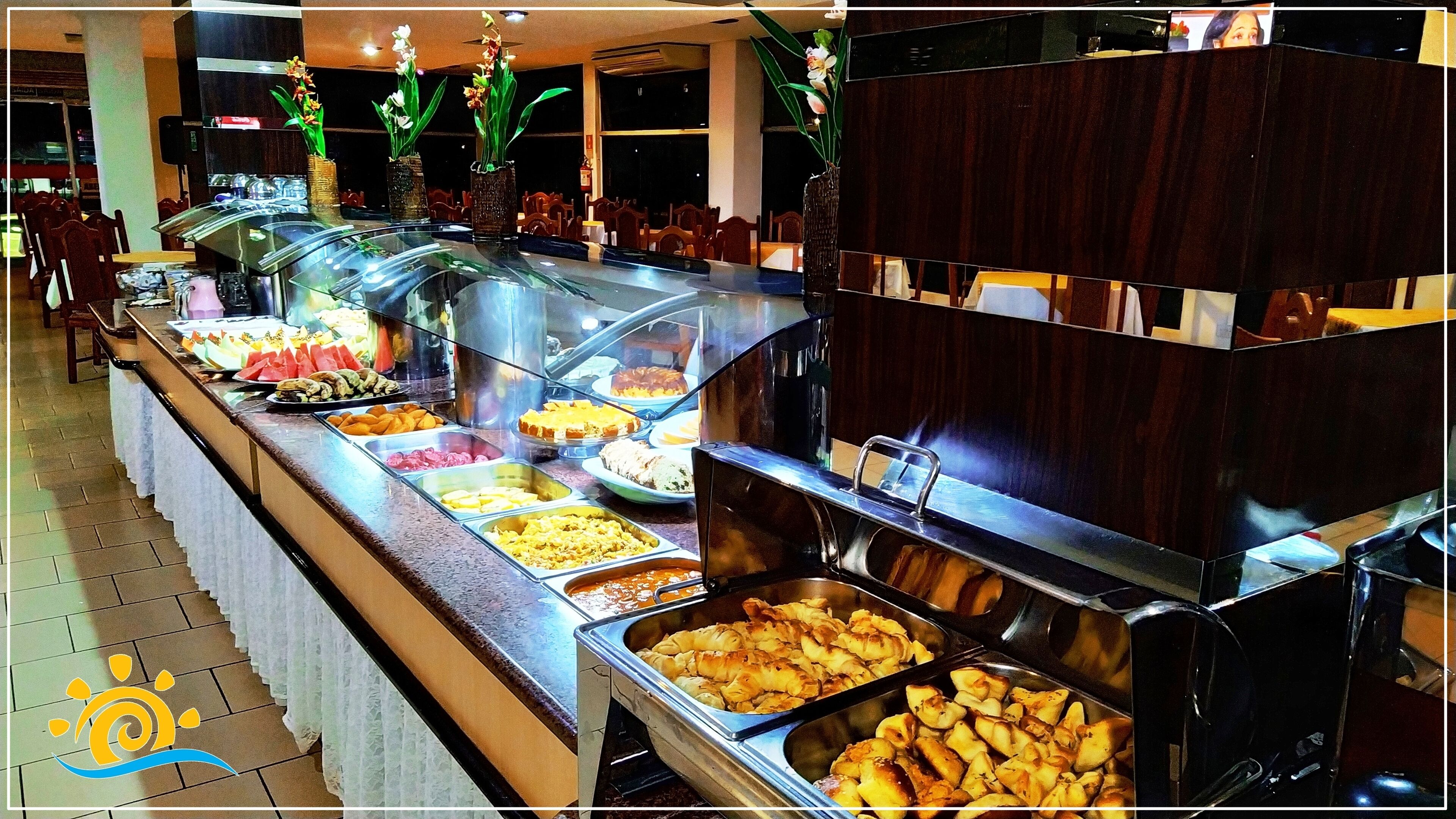 Ein reichhaltiges Buffet mit verschiedenen Speisen, darunter Obst, Gemüse und zubereitete Gerichte.