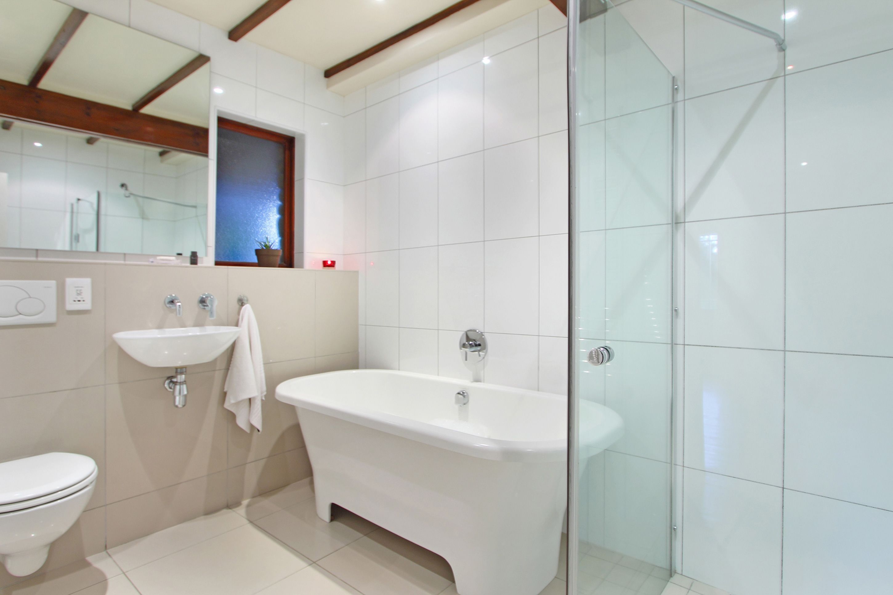 A modern bathroom with a freestanding bathtub, a sink, and a toilet.