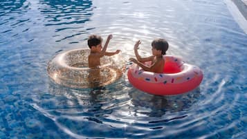 Children enjoy splashing around in the pool with fun inflatable rings.