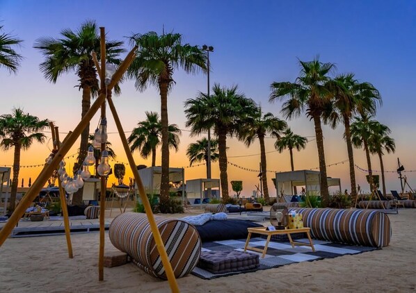 On the beach, white sand, sun-loungers, beach umbrellas
