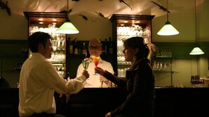 A bar area with a bartender, a customer, and a drink. - Krokodil Restaurant & Hotel (Heidelberg)