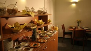 A buffet setup with various food items and beverages, including a pineapple, bowls, and plates. - Krokodil Restaurant & Hotel (Heidelberg)