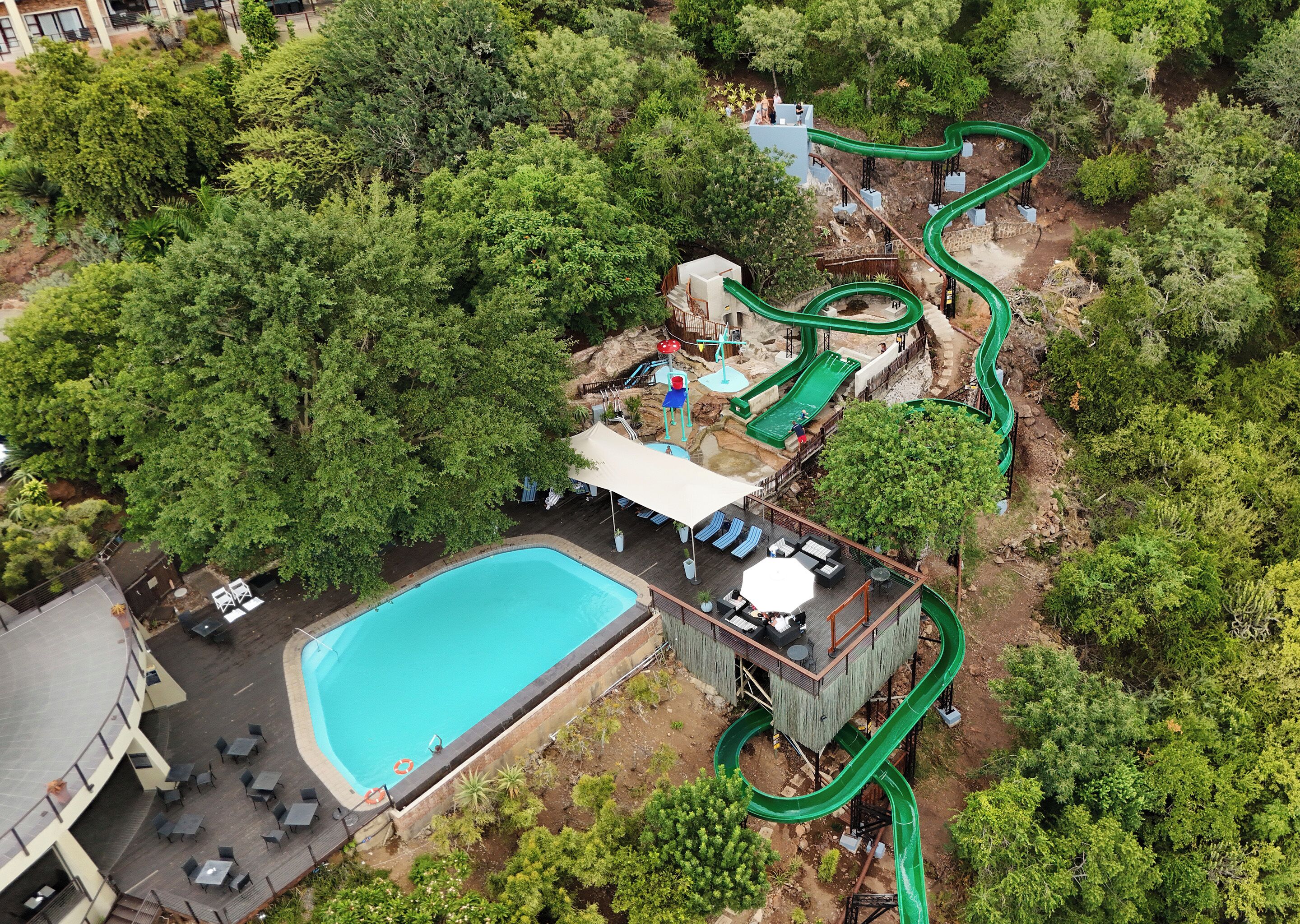 Vista aérea de um resort com piscina, área de estar e um toboágua.