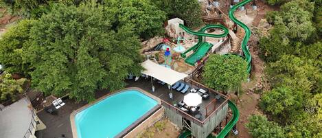 Vista aérea de um resort com piscina, área de estar e um toboágua.