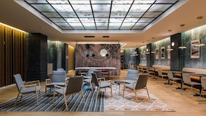 Een moderne lounge met dakraam, zitgedeelte en een patroonwand.