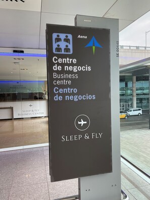 A sign for the Sleep & Fly Business Center at an airport, indicating amenities for travelers. - Sleep & Fly (El Prat de Llobregat)