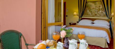 Habitación de hotel con desayuno que incluye frutas, bollería y servicio de té o café.