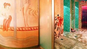 Habitación con un mural de una mujer y un niño, suelo estampado y pared verde con una puerta.