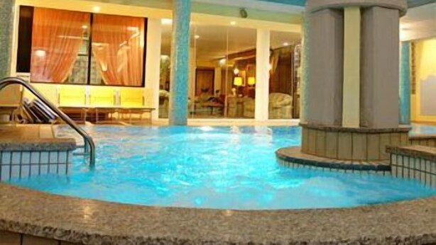 Una piscina interior con vista despejada del entorno circundante, incluyendo una zona de estar con vistas a la piscina.