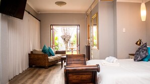 Una habitación de hotel con una cama, un sofá, una silla, una mesa y un televisor.