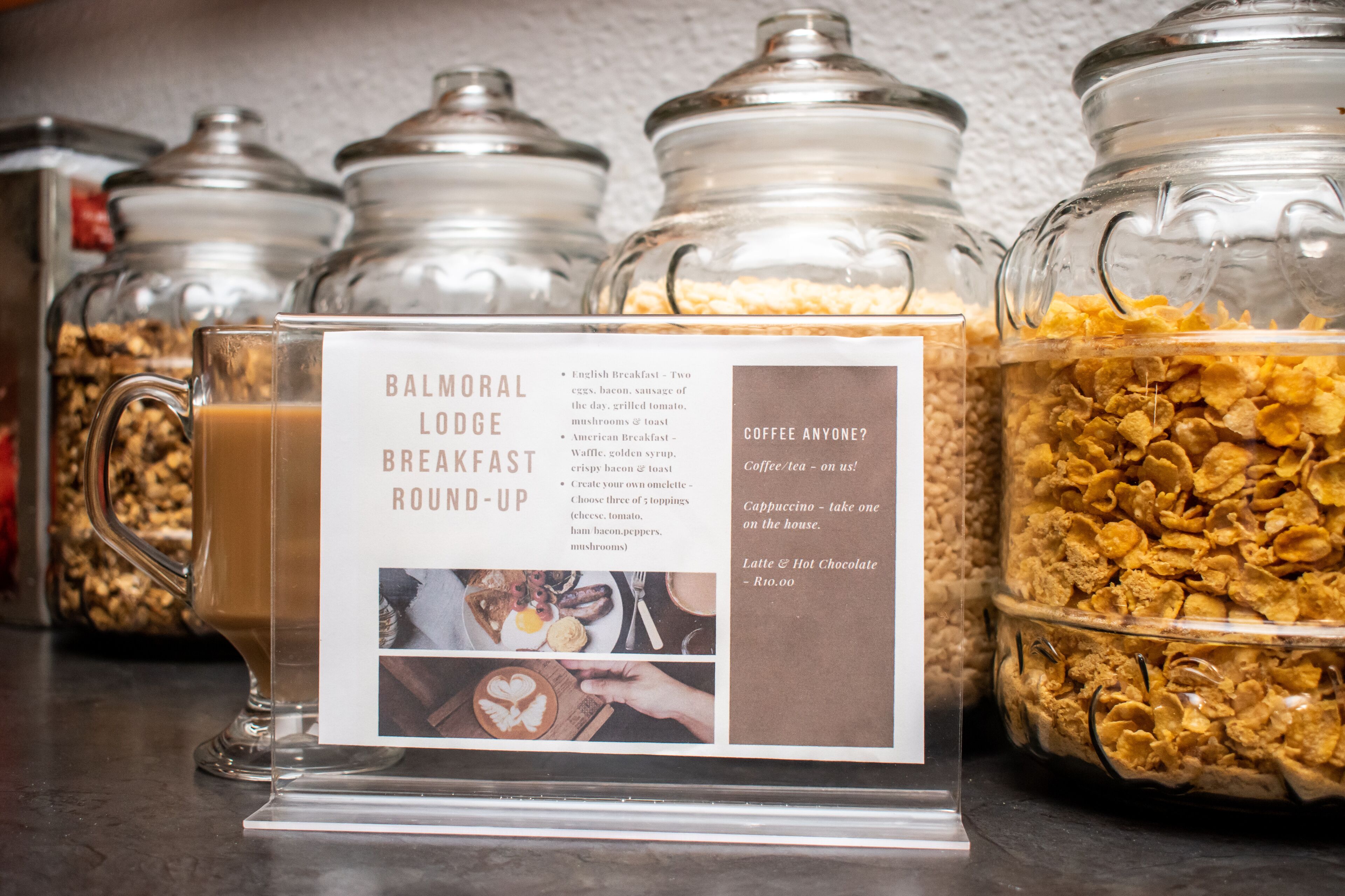 A breakfast display with various food options and a menu board.