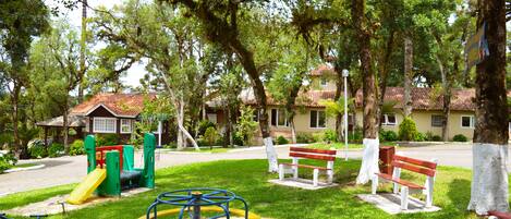 A playground with swings, a slide, and a seesaw.