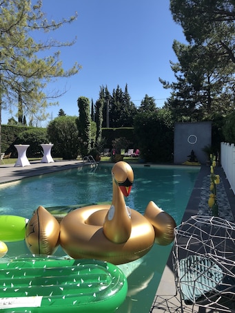 Una piscina al aire libre de temporada, sillones reclinables de piscina
