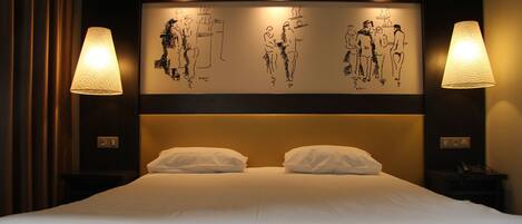 Habitación de hotel con una cama grande, dos lámparas de noche y una pared con bocetos en blanco y negro.