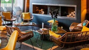 A modern interior with wicker furniture, a fireplace, and artwork on the wall. - Safari Hotel (Carpentras)