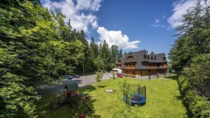 A large house with a well-maintained lawn and a trampoline in the yard. - Dwór Karolówka (Zakopane)