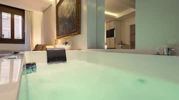 Un bagno moderno con una vasca da bagno ampia, uno specchio, un lavabo e una televisione.