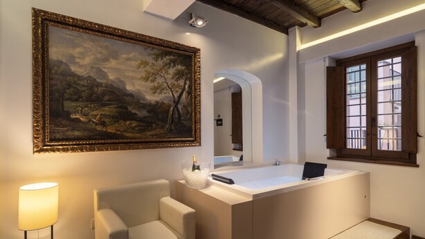 Een moderne badkamer met een groot schilderij, een badkuip, een stoel en een raam.