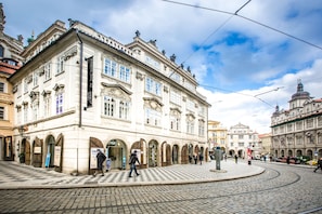A historic building with arched windows and a central entrance, surrounded by cobblestone streets and other historic architecture. - Miss Sophie's Charles Bridge (Prague)