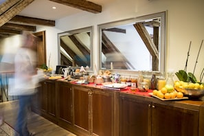 A breakfast buffet with various food items and beverages, wooden cabinets, and large mirrors. - Miss Sophie's Charles Bridge (Prague)