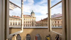 En utsikt från ett fönster med utsikt över en historisk byggnad med en kupol och klassisk arkitektur.