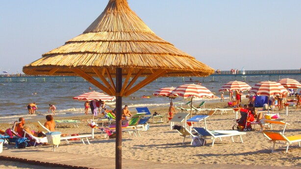 A beach with thatched umbrellas and sun loungers. - Residence Cleo (Comacchio)