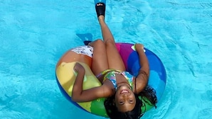 A person lying on a colorful inflatable float in a swimming pool. - Residence Cleo (Comacchio)