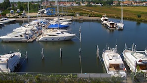 A marina with multiple yachts docked. - Residence Cleo (Comacchio)