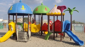 A beach playground with multiple slides and climbing structures. - Residence Cleo (Comacchio)