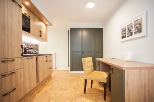 Una cocina moderna con armarios de madera, microondas integrado y encimera de madera.