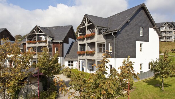 A row of modern, multi-story residential buildings with balconies and a well-maintained lawn. - Hapimag Resort Winterberg (Winterberg)