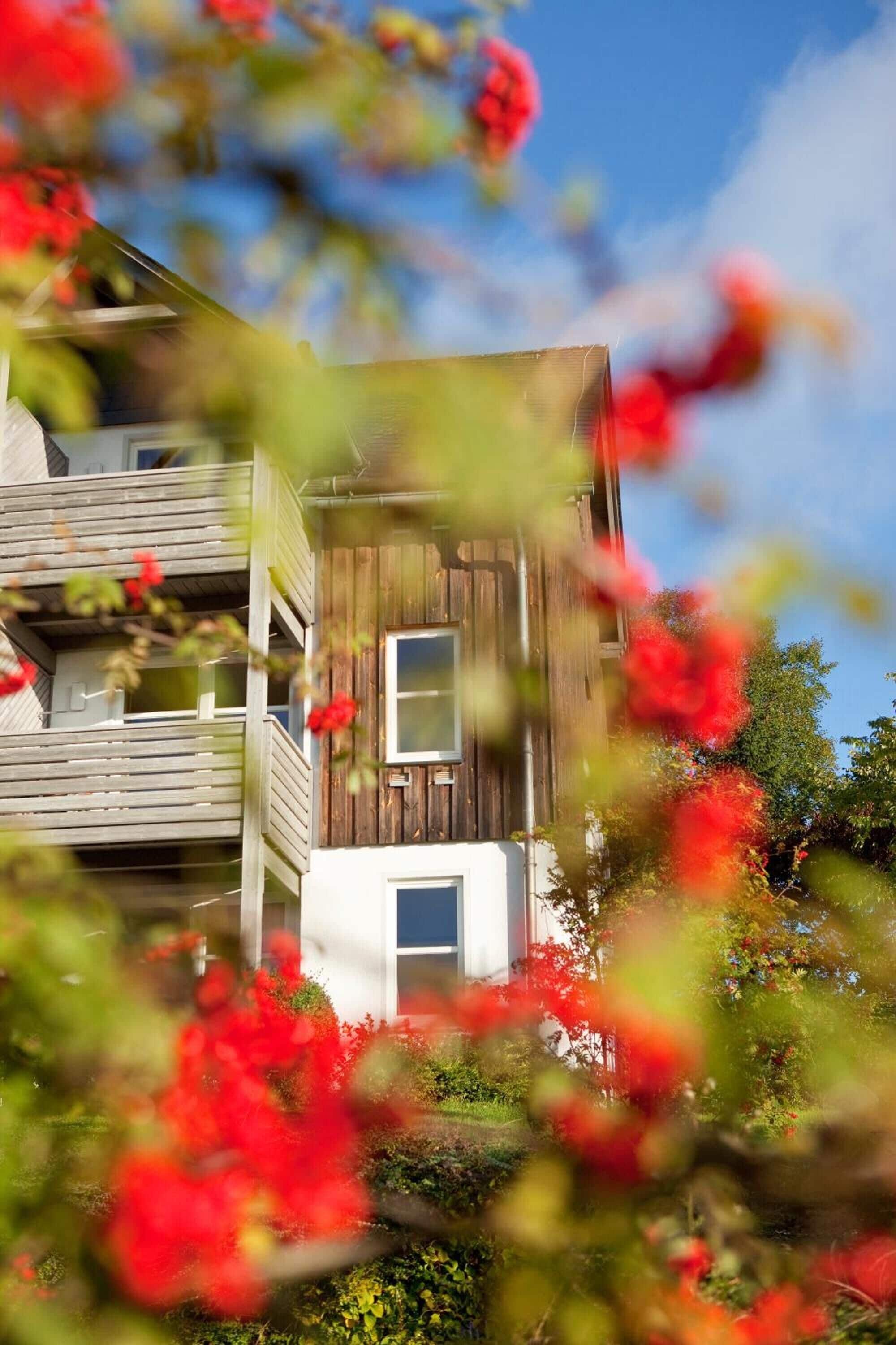 Ein zweistöckiges Holzhaus mit Balkonen und einem weißen Fenster.
