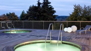 A wooden deck with a circular hot tub and lounge chairs. - Hapimag Resort Winterberg (Winterberg)
