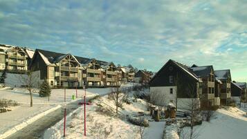 Zona residencial con edificios de varios pisos, paisaje cubierto de nieve y cielo despejado.