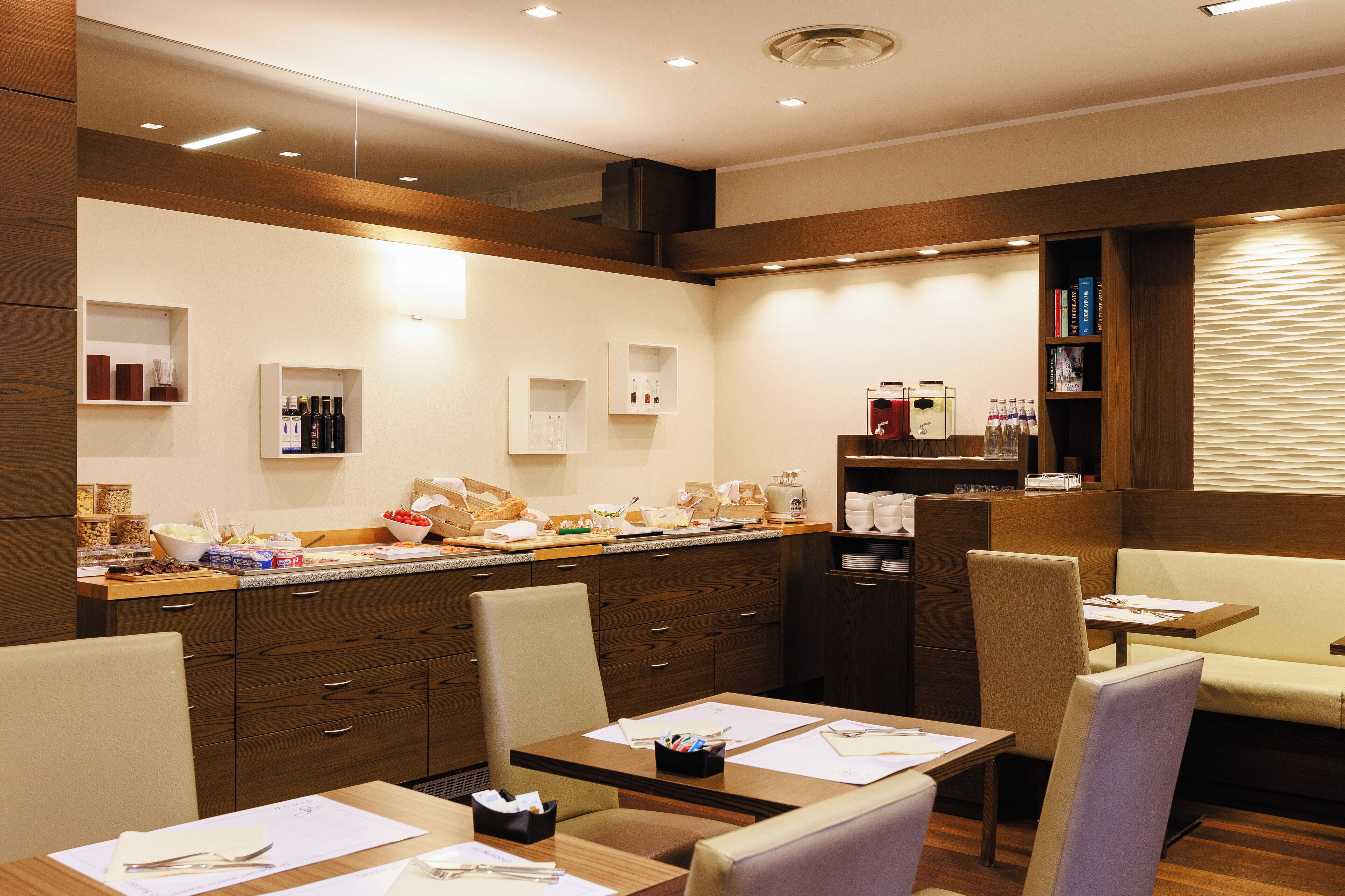 A modern hotel lobby with a reception desk, seating area, and a coffee station.