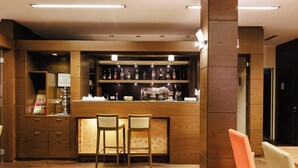 A bar area with wooden furniture, a counter, and shelves with bottles.