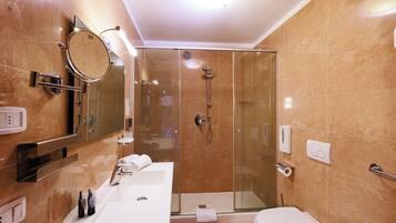 Un bagno moderno con doccia vetrata, lavandino bianco e servizi igienici.