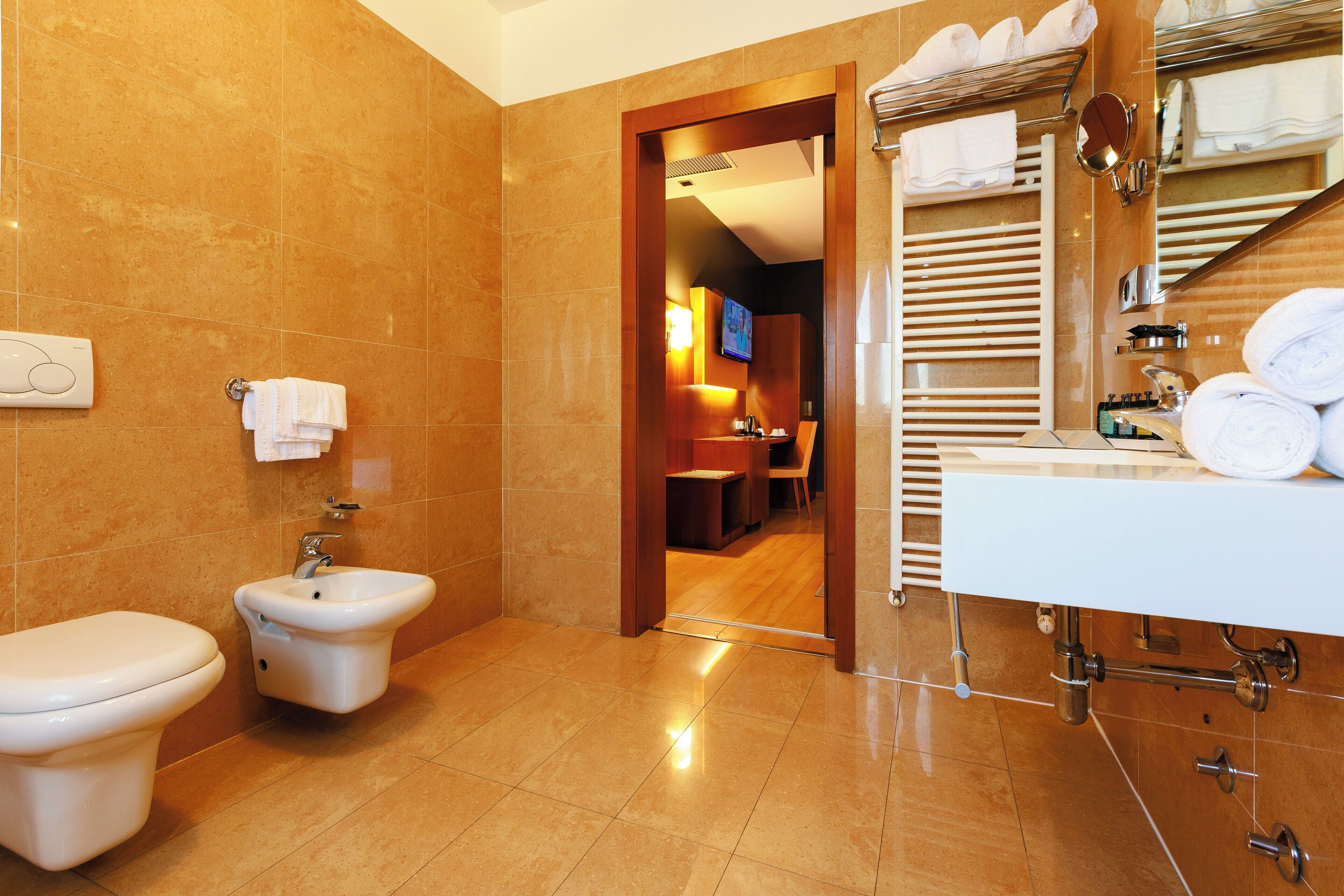 A modern bathroom with a toilet, bidet, and sink.
