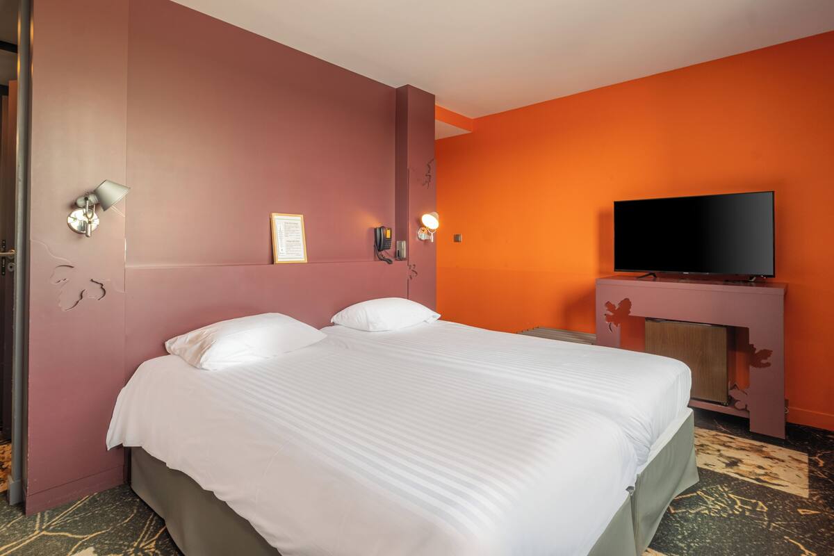 Une chambre d’hôtel avec un grand lit, une télévision à écran plat et une cheminée.