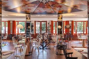 Un restaurante espacioso con techos altos, ventanas amplias y una estructura central que recuerda a un árbol.