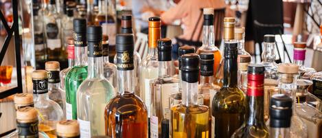 Un bar con varias botellas de licores y vasos.